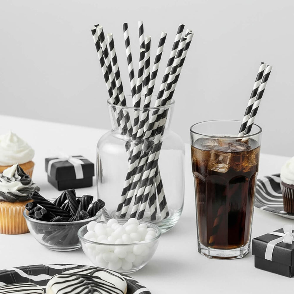 Monochrome theme party table with black and white straws and a glass of cola