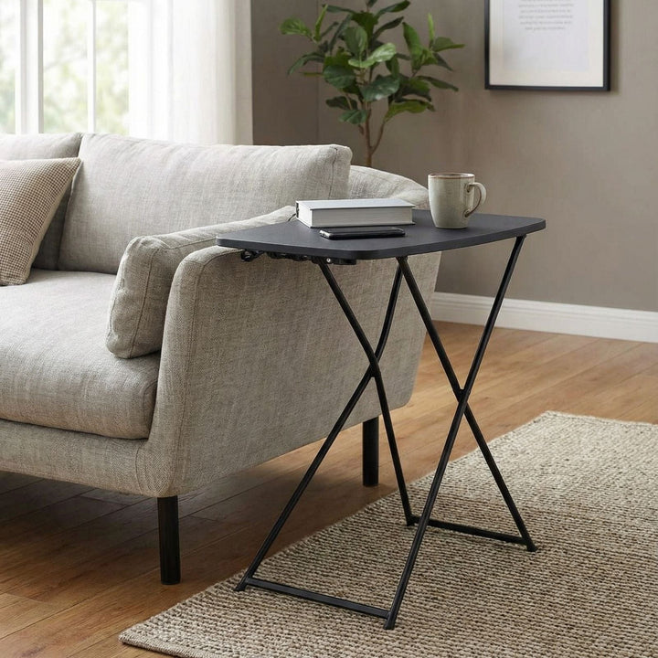 side table beside sofa in living room with mug, book and phone resting on top