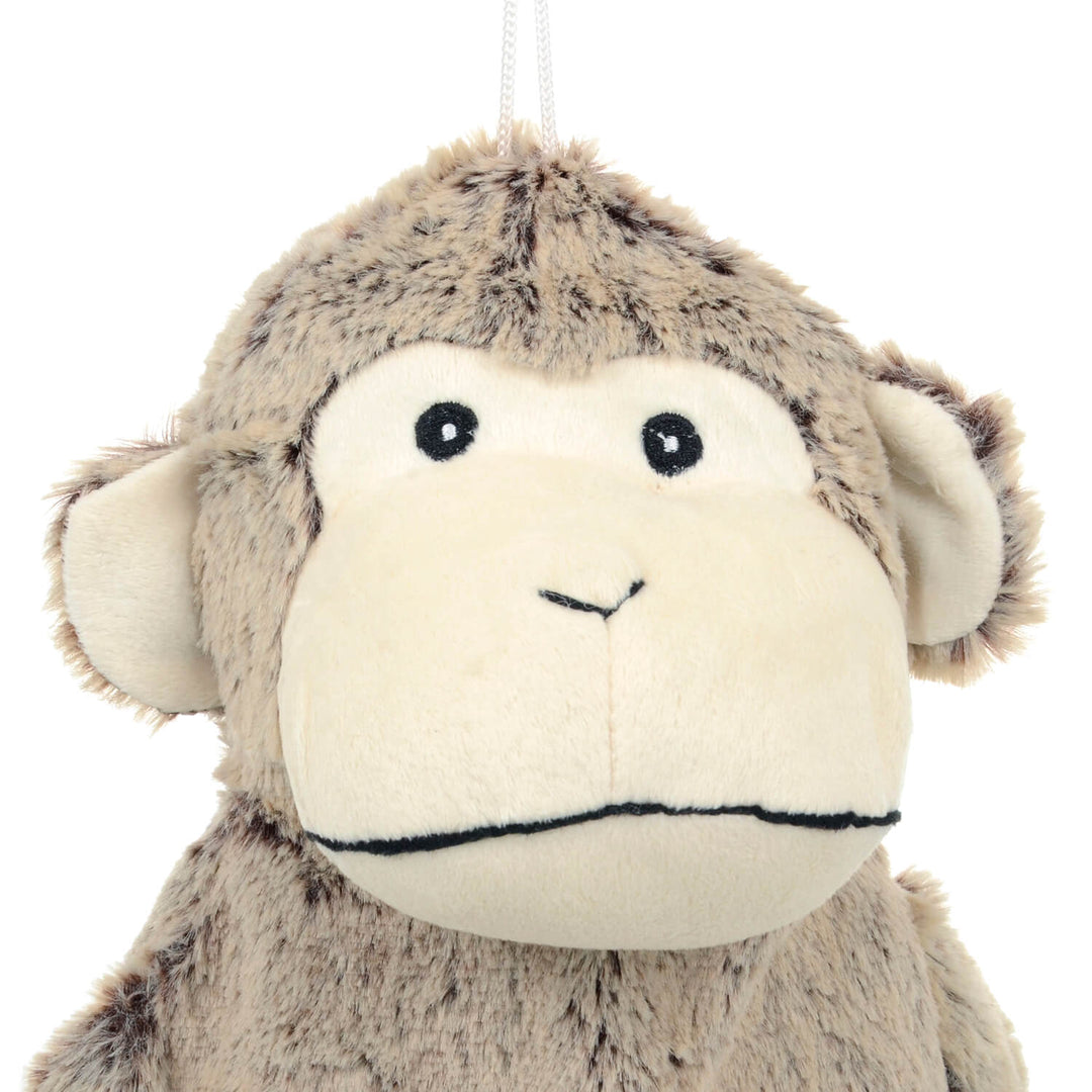 Close up of the head of a plush monkey hot water bottle cover on a white background