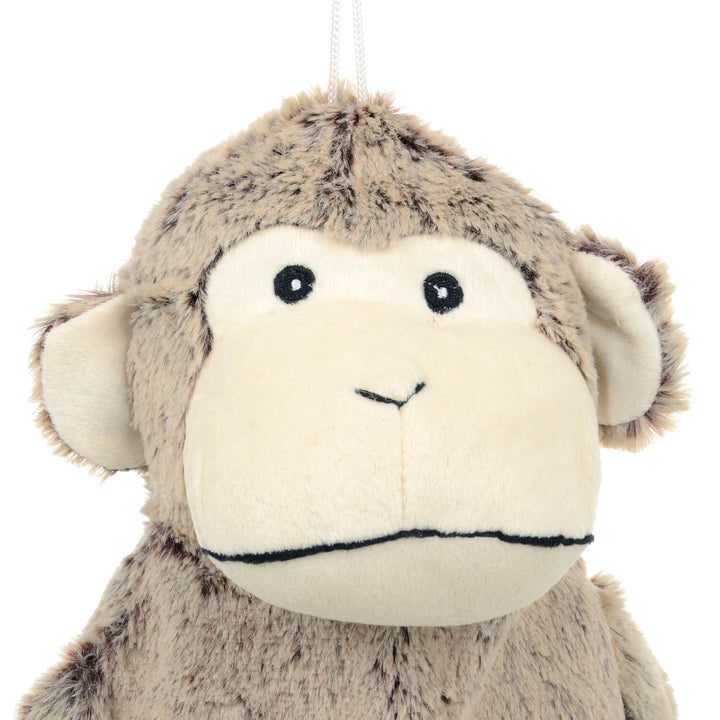 Close up of the head of a plush monkey hot water bottle cover on a white background