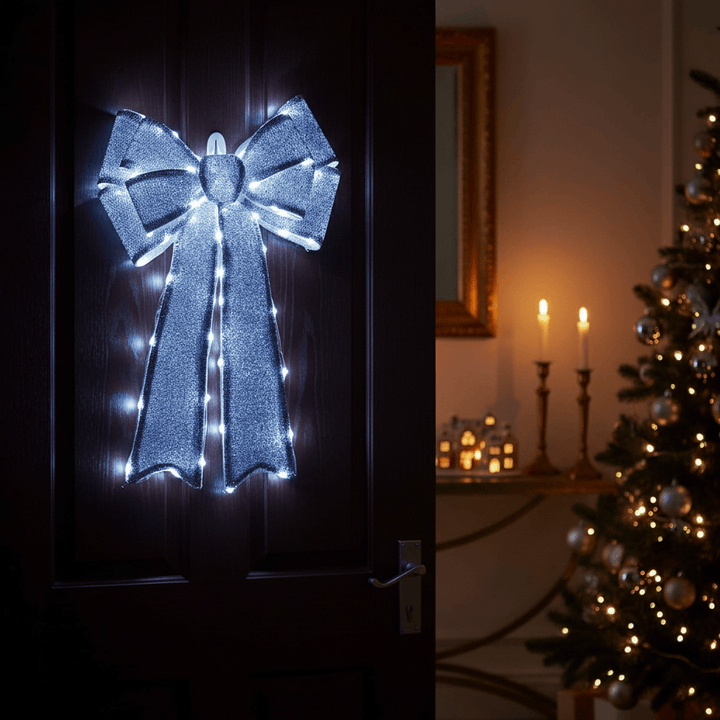 Decorative bow with lights on a door next to a Christmas tree with lights.