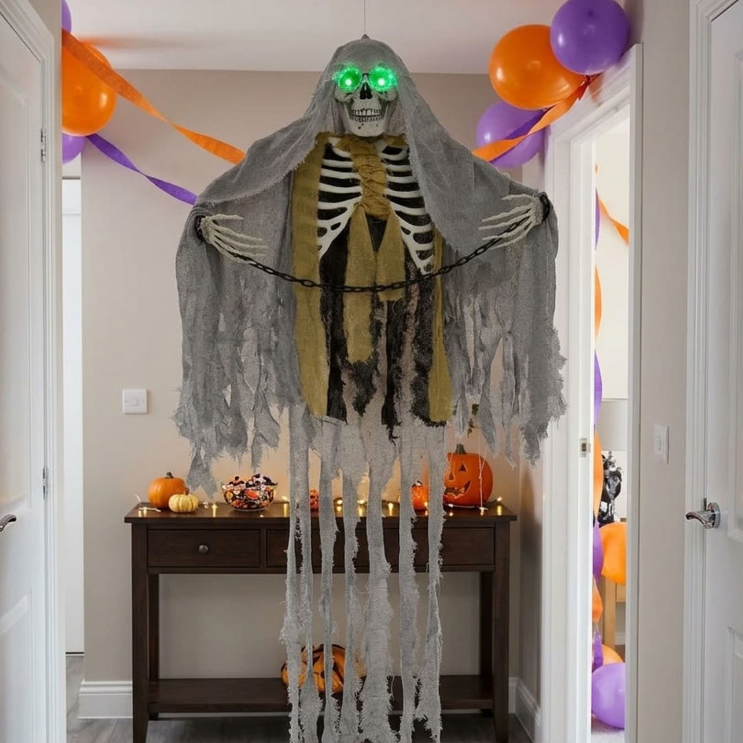 skeleton decoration hanging from ceiling in hallway with purple and orange balloons and consol table in background with candy and pumpkin