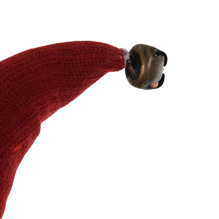 Red knitted fabric santa hat with a bronze bell on a white background