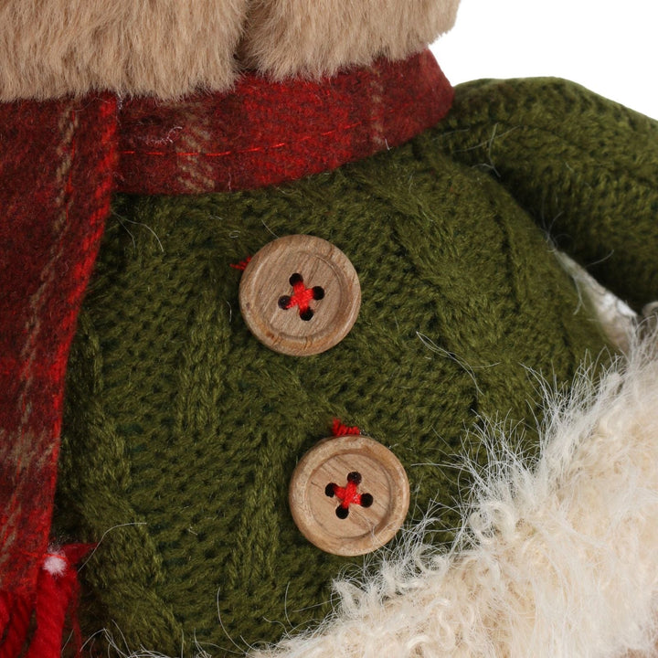 Close-up of a knitted green garment with wooden buttons on a white background