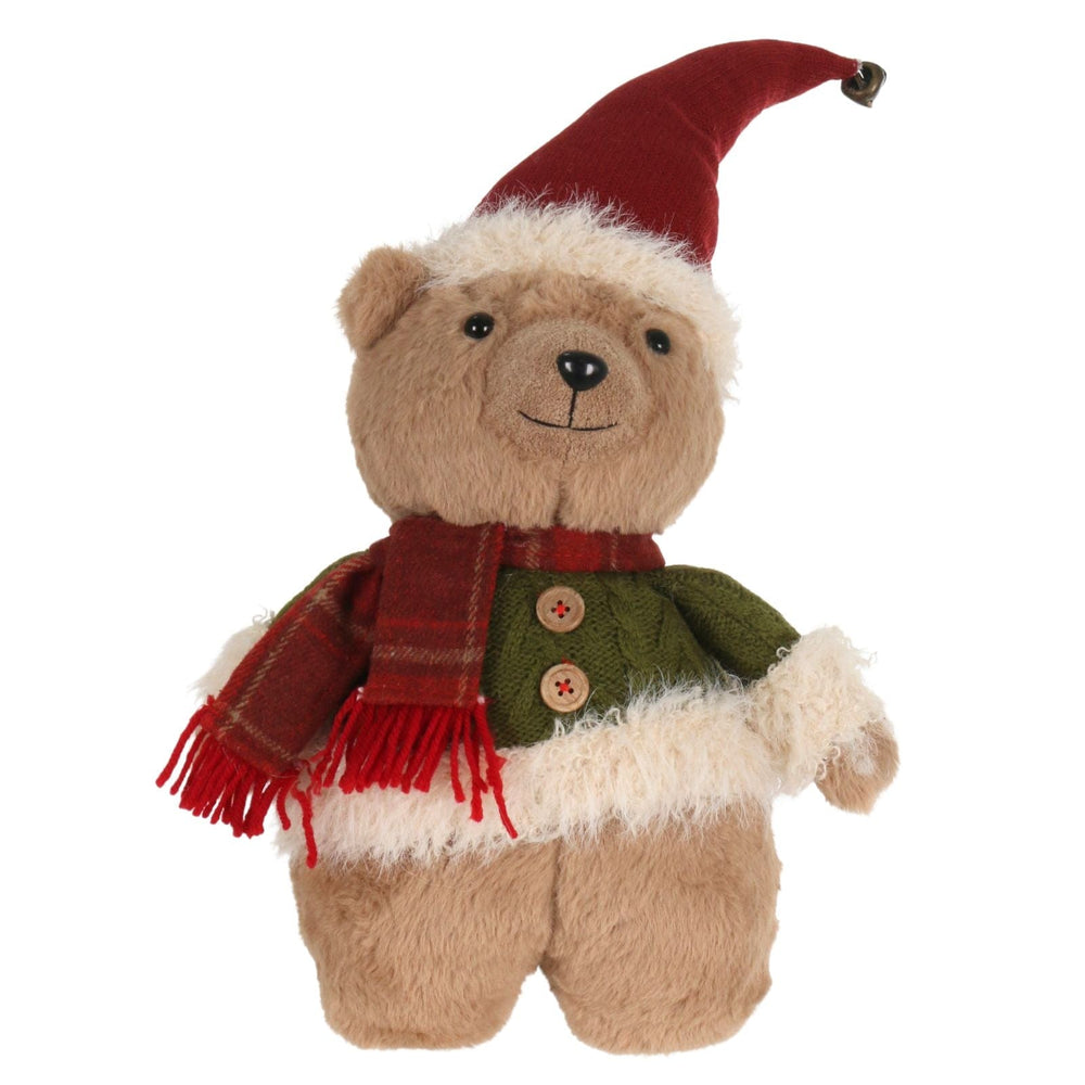 Plush teddy bear wearing a Santa hat, green vest, and red scarf on a white background