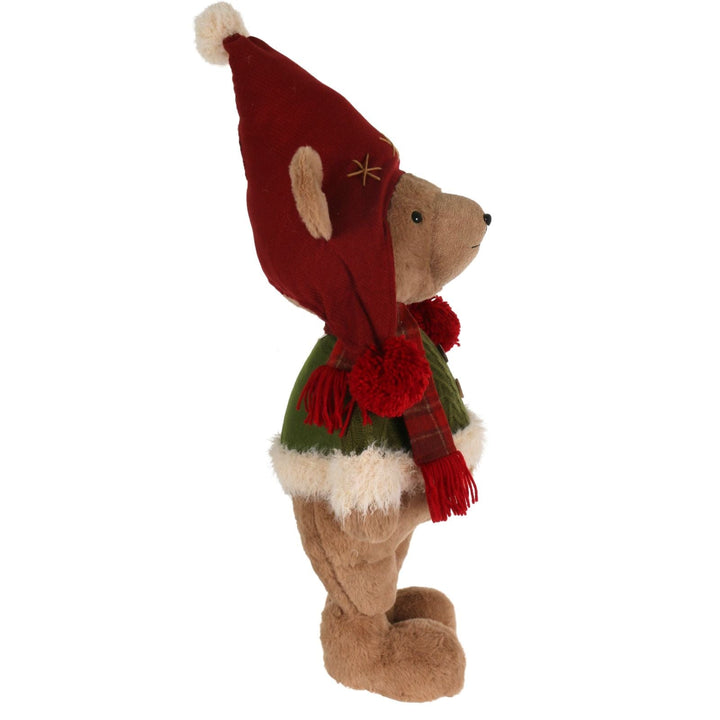 Stuffed bear toy wearing a red hat, scarf, and green outfit on a white background