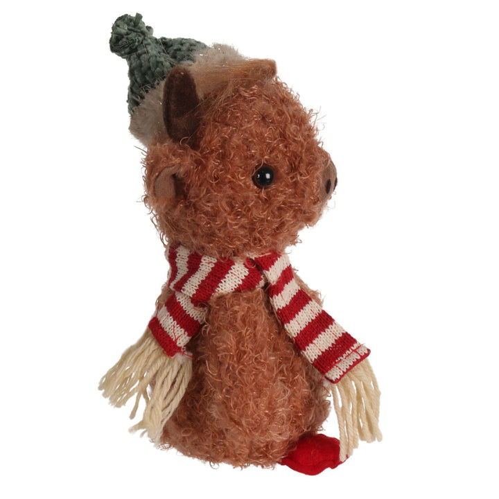 side view of highland cow plush decoration wearing striped scarf and green hat