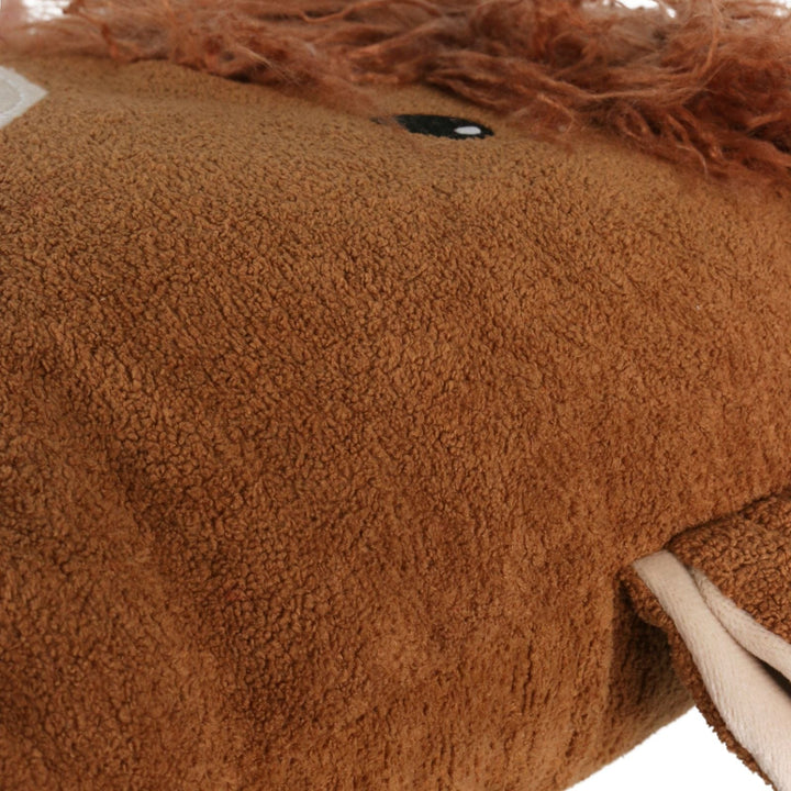 Close-up of a brown plush cushion from the side on a white background