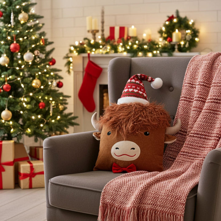 Decorative pillow with a cow design on a gray armchair in a festive living room.
