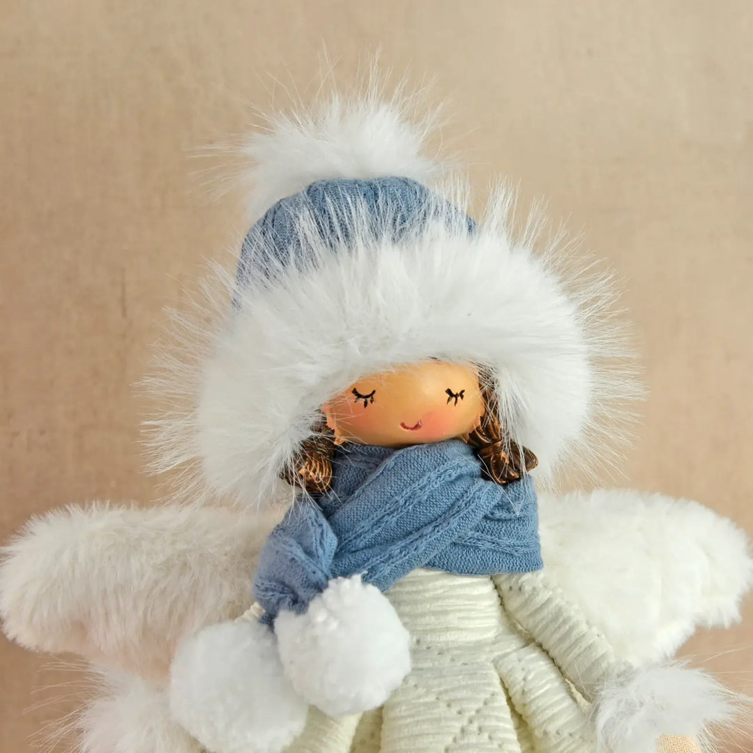 Close up of a fairy figure decoration with blue and white fluffy accessories