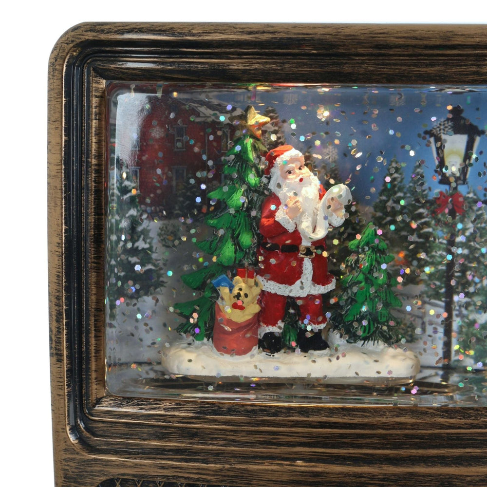 Decorative scene with Santa Claus, a dog, and a Christmas tree in a tv frame
