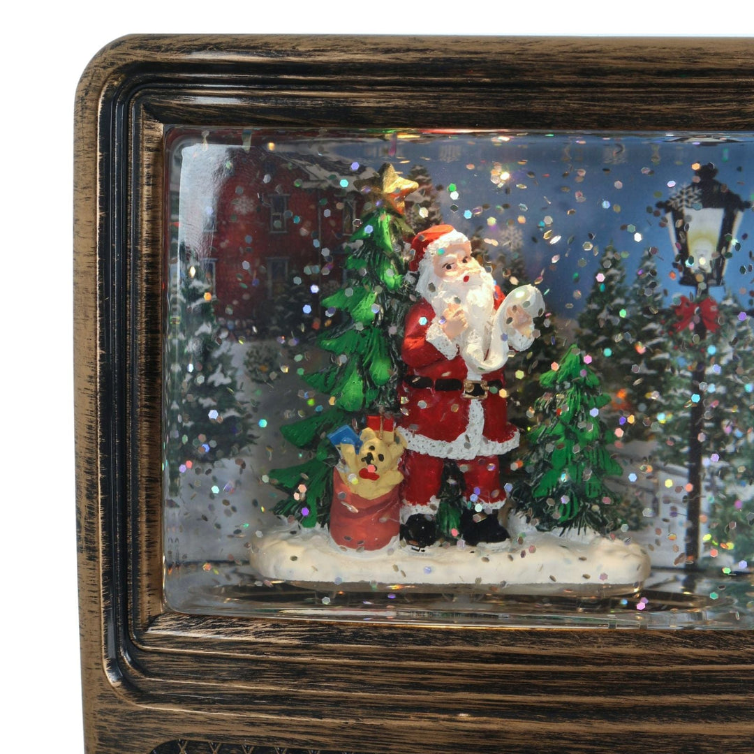 Decorative scene with Santa Claus, a dog, and a Christmas tree in a tv frame