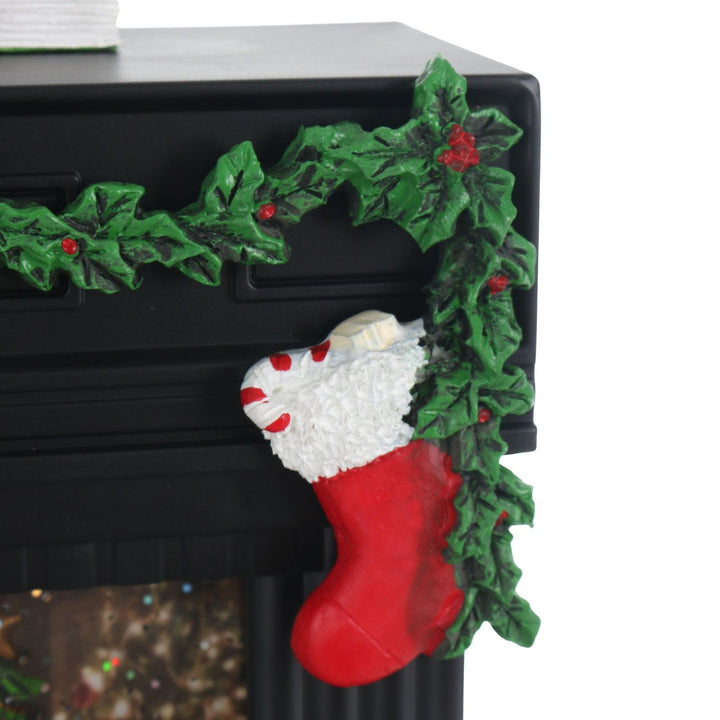 Decorative Christmas stocking hanging on a fireplace with holly leaves and berries.