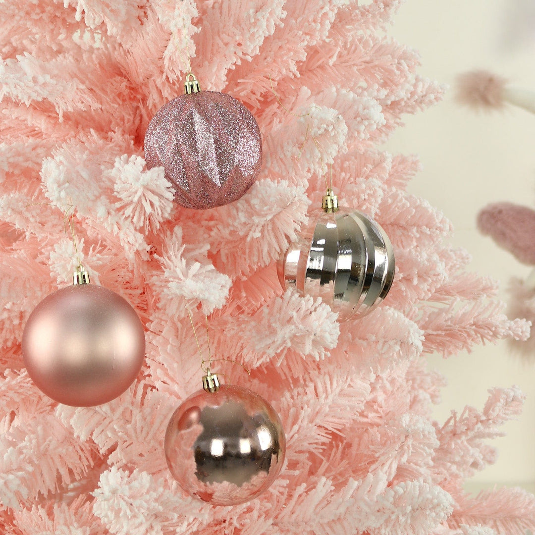 Decorative Christmas pink tree decorations on a pink and white tree.