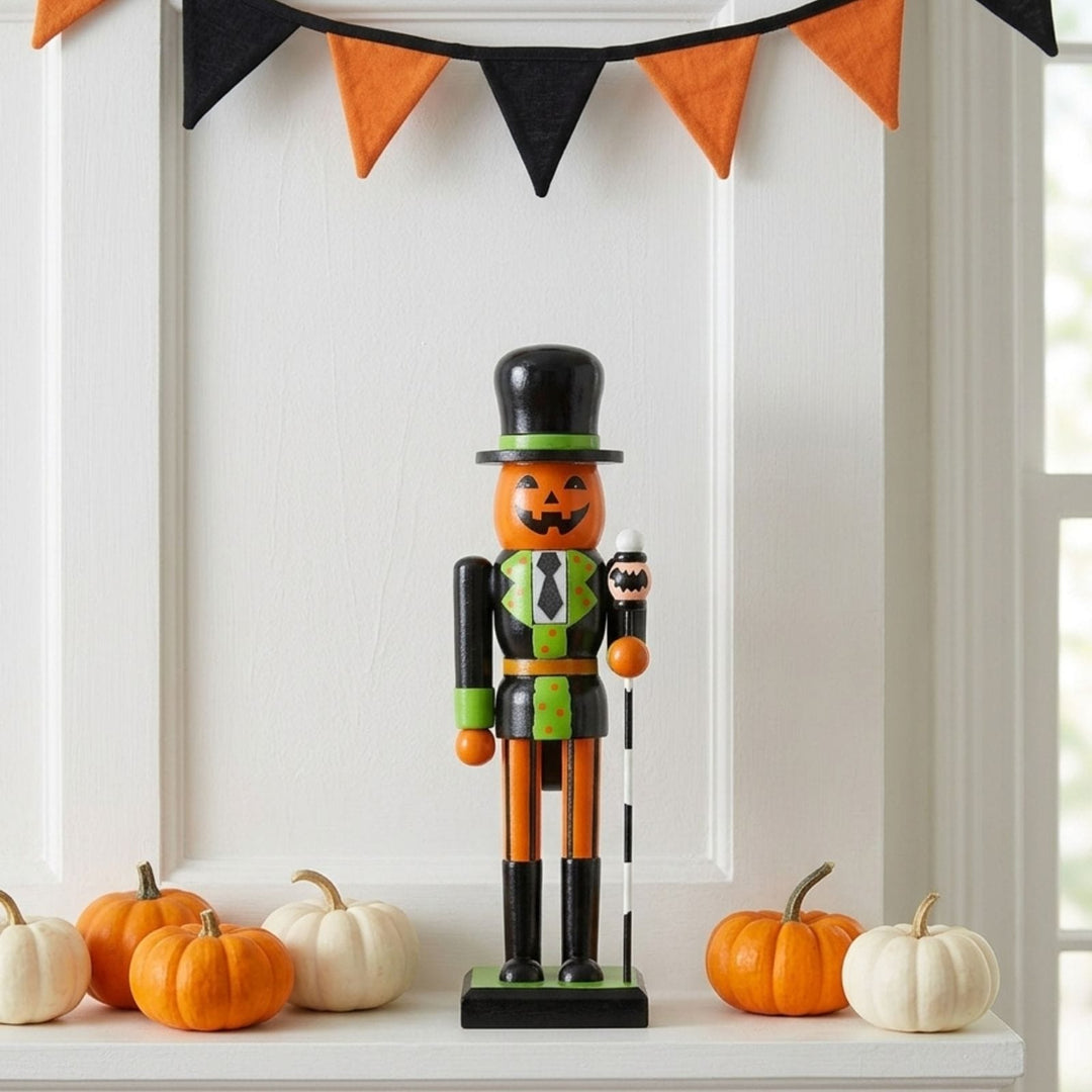 pumpkin nutcracker decoration on fireplace ledge beside mini pumpkins with orange and black bunting to the top