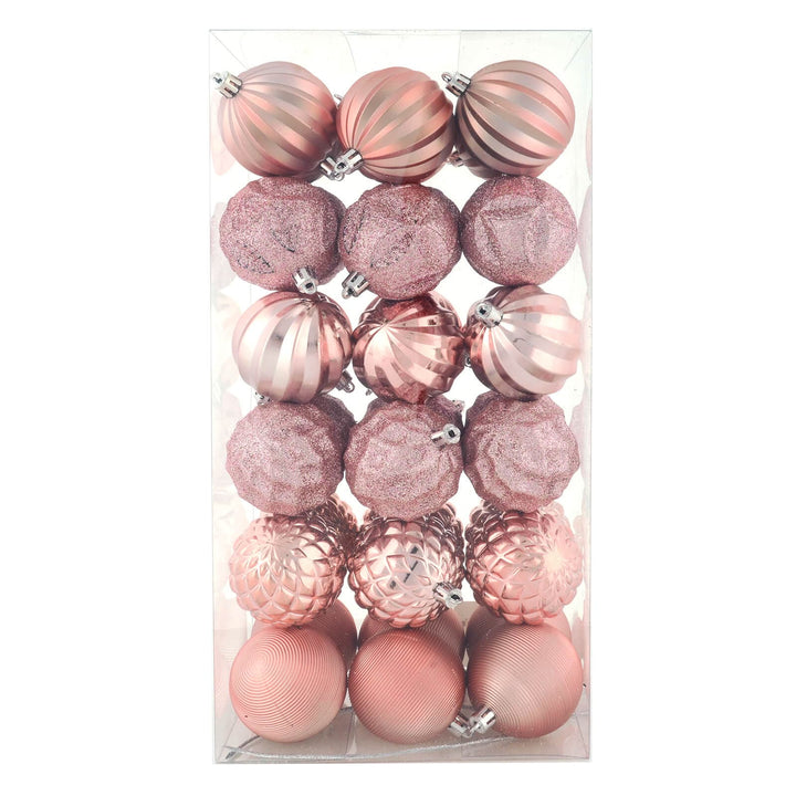 Set of pink and rose gold Christmas ornaments in a clear packaging box.