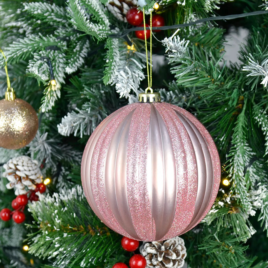 Extra large pink and silver striped Christmas tree bauble on a decorated tree