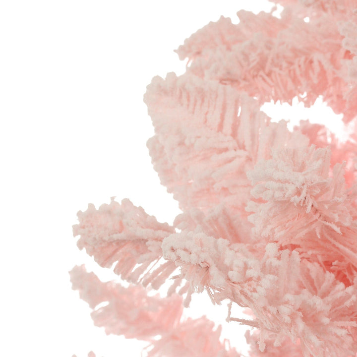 Close-up of a pink artificial Christmas tree branch on a white background