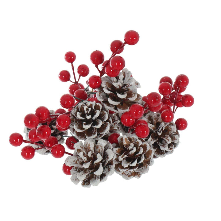 pile of pine cones with snow covered edges and red berry clusters