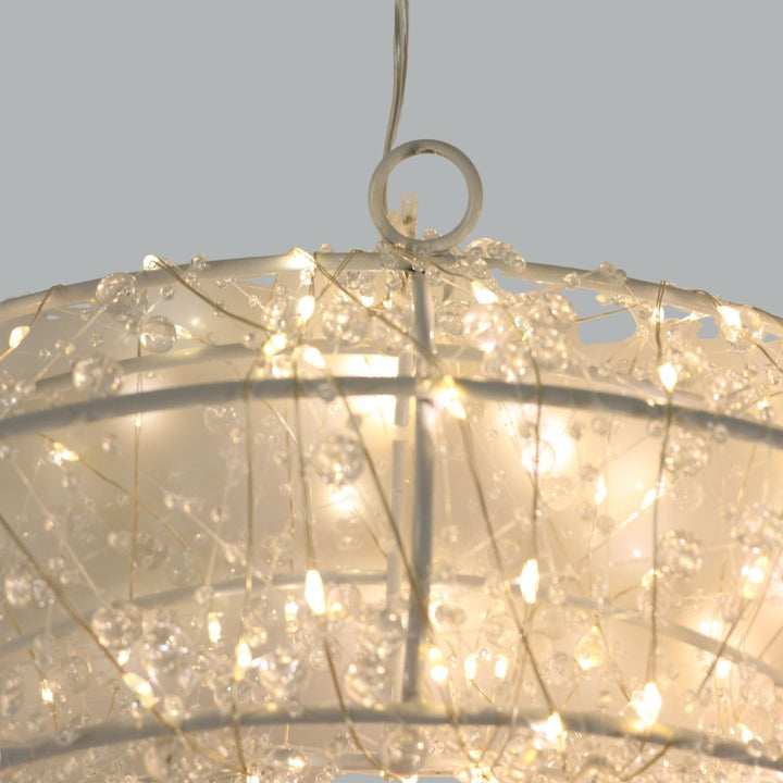 Close-up of a decorative light fixture with string lights against a neutral background