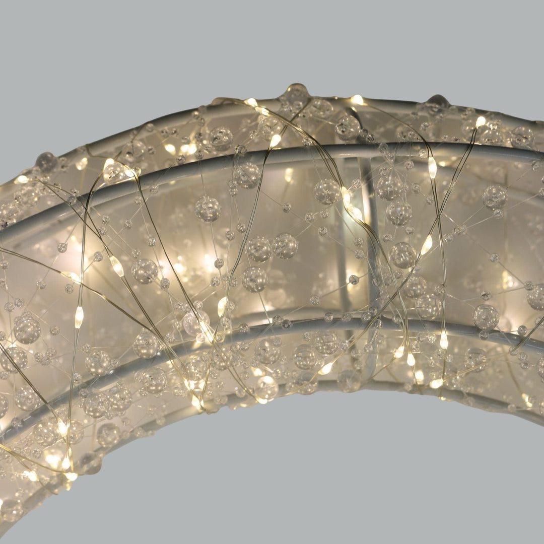 Close-up of a decorative ring with crystal-like stones on a light grey background