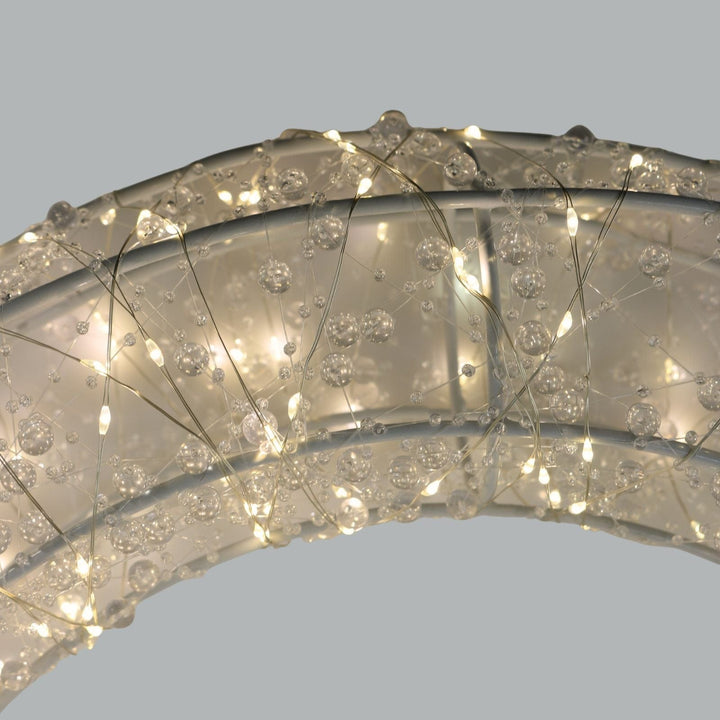 Close-up of a decorative ring with crystal-like stones on a light grey background
