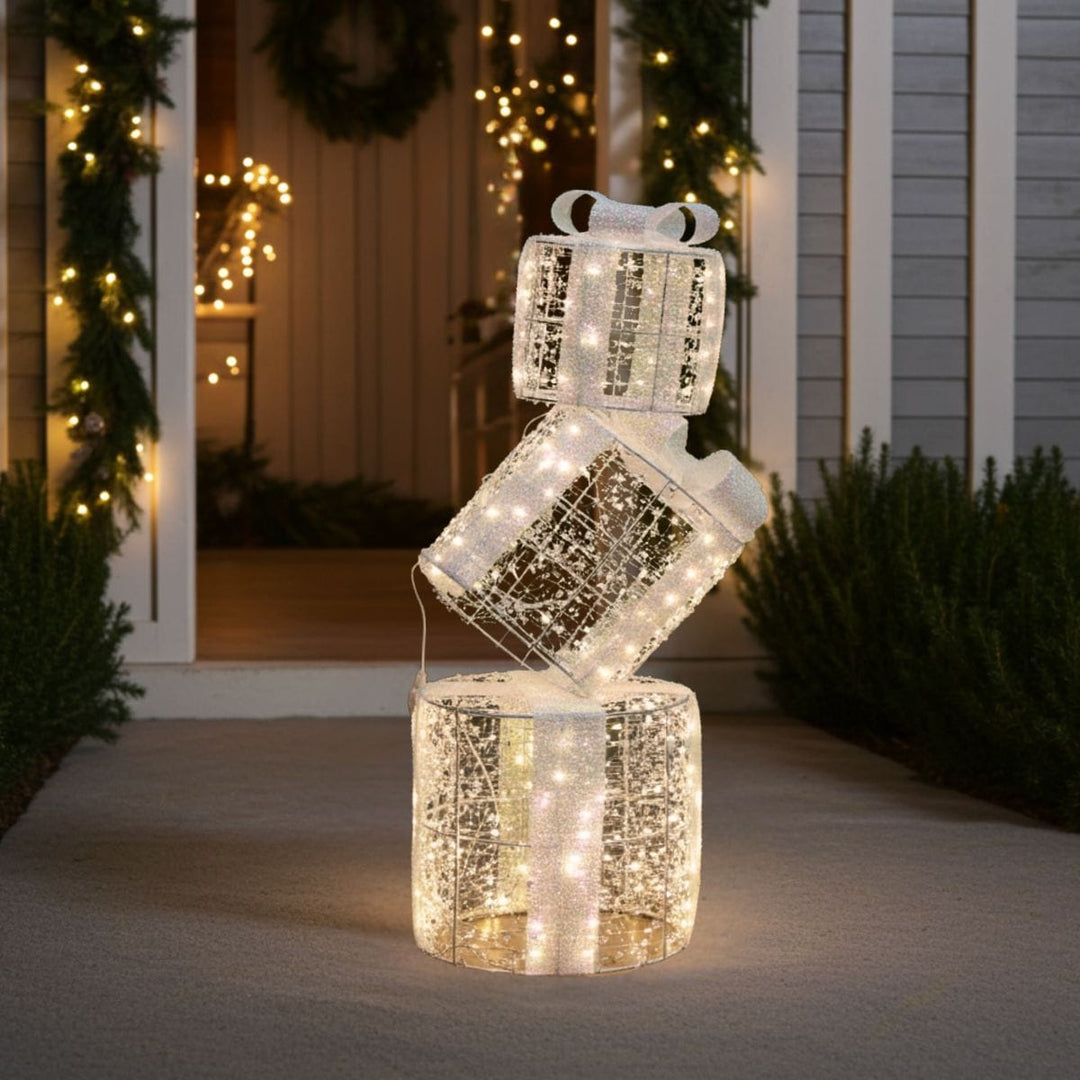 Decorative gift boxes stacked s on a porch with Christmas decorations.