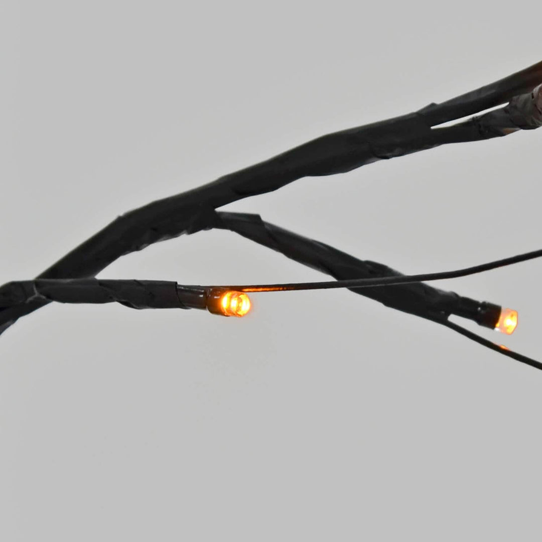 Close up of orange LED lights on a black twig tree