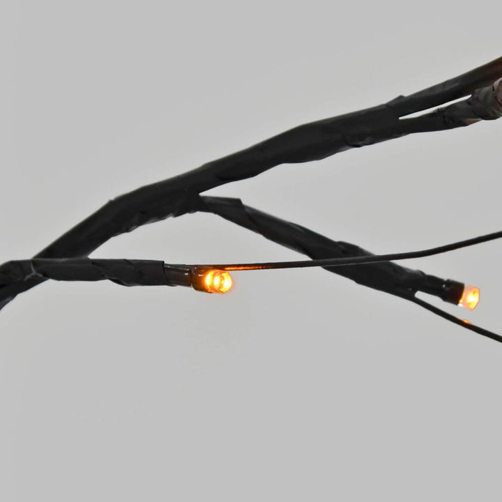 Close up of orange LED lights on a black twig tree