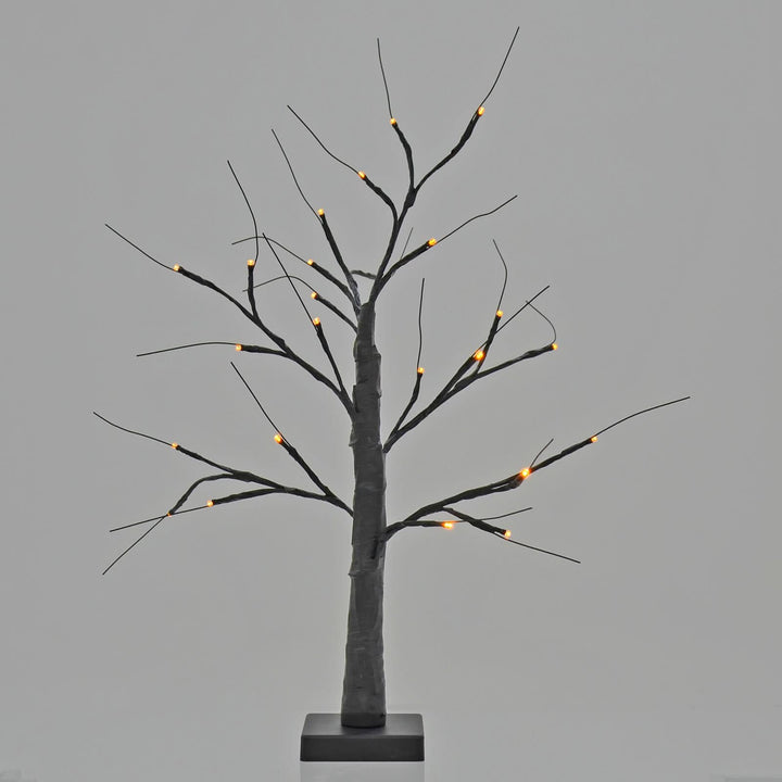 Halloween black twig tree lit up with orange lights