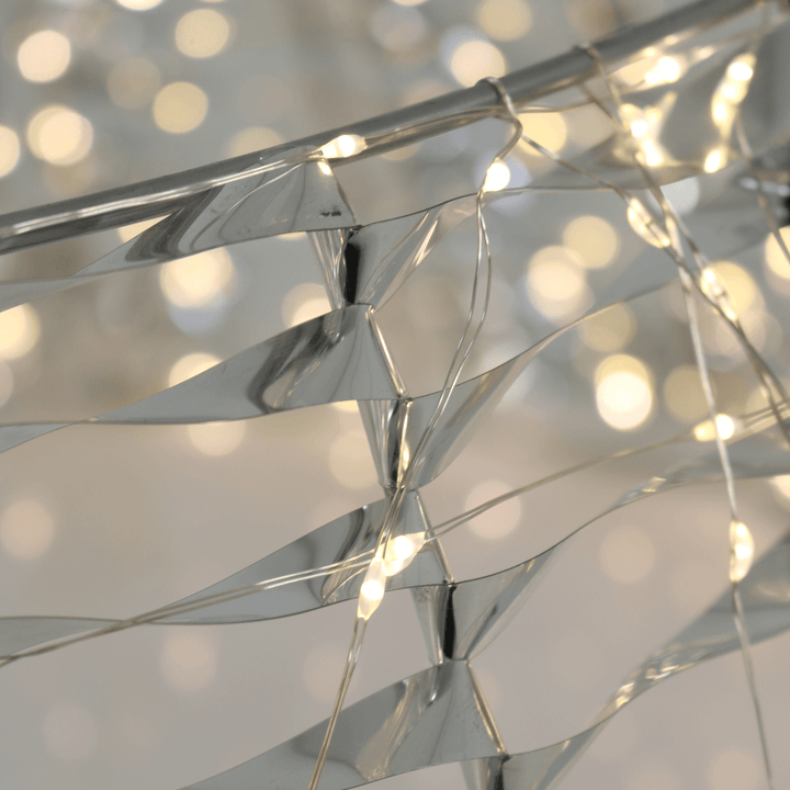 close up of warm white light and silver PET material with blurred lights in the background
