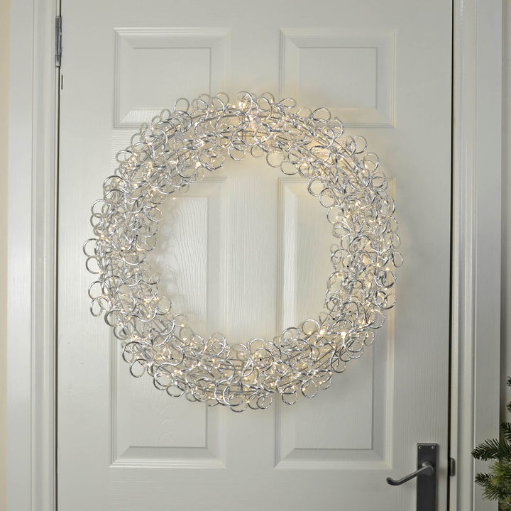 Decorative Christmas wreath with lights on a white wooden  panelled door