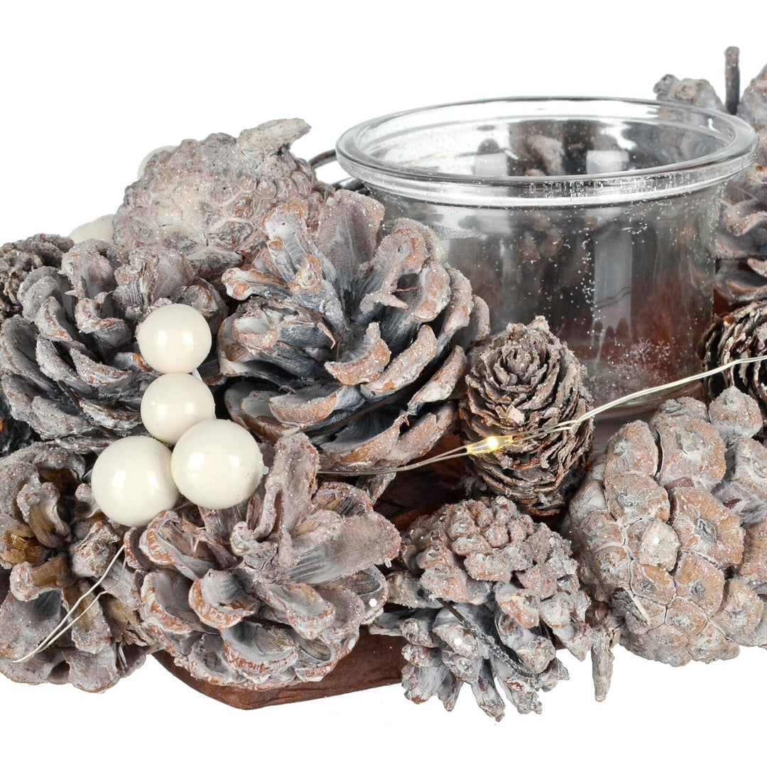 Close up of white berries and pine cones Christmas candle holder with warm white LED lights