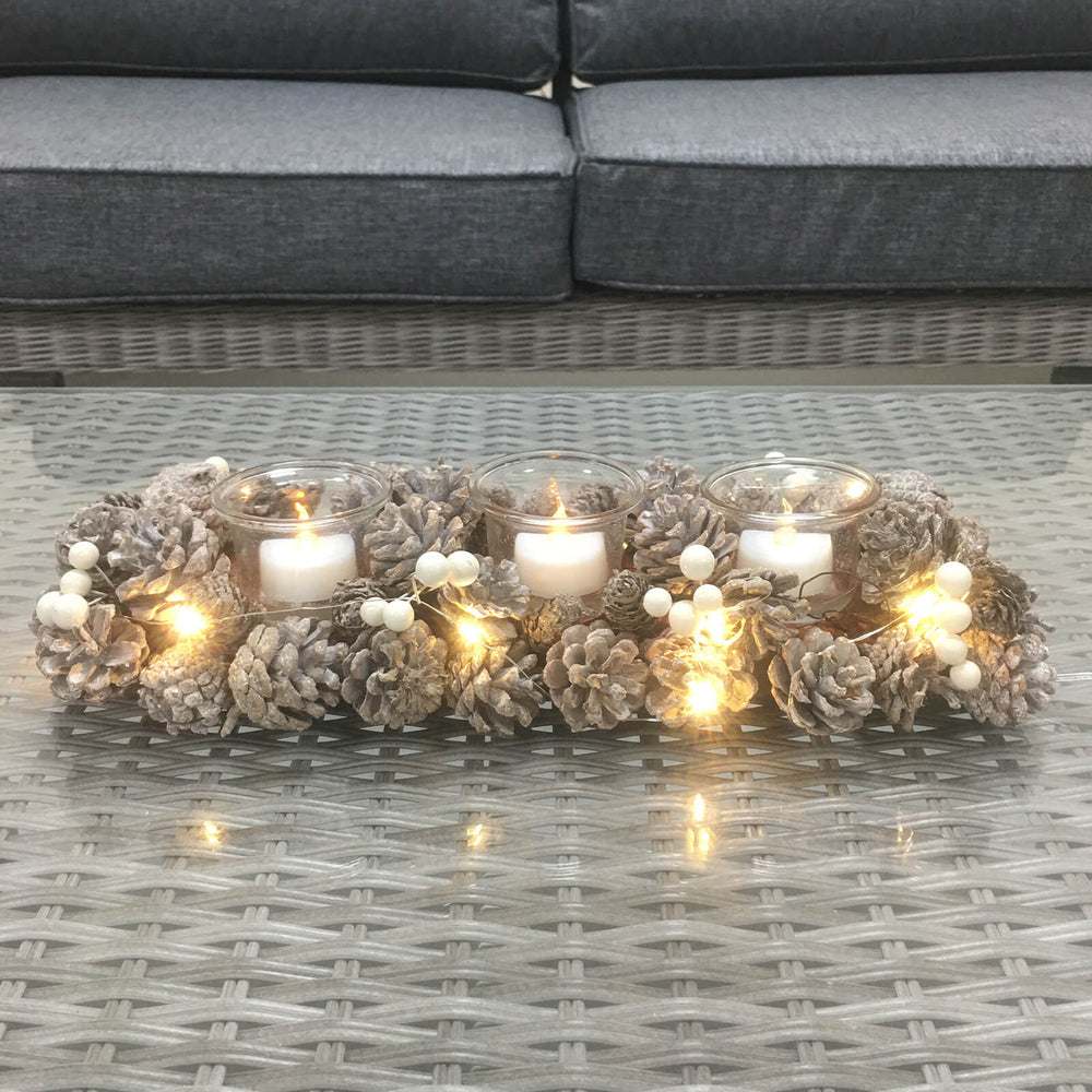 Decorative wreath with candles and lights on a glass table