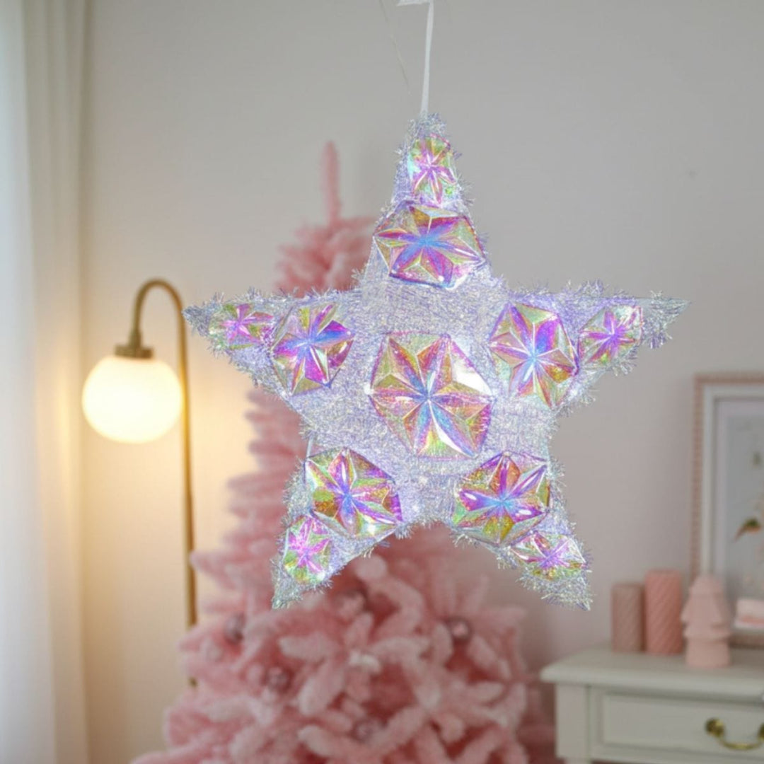 star light hanging in room with pink christmas tree and consol table in the background
