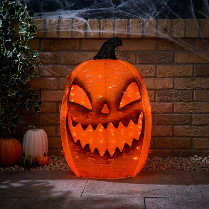 orange pumpkin light in garden with brick wall in background orange spooky lighting