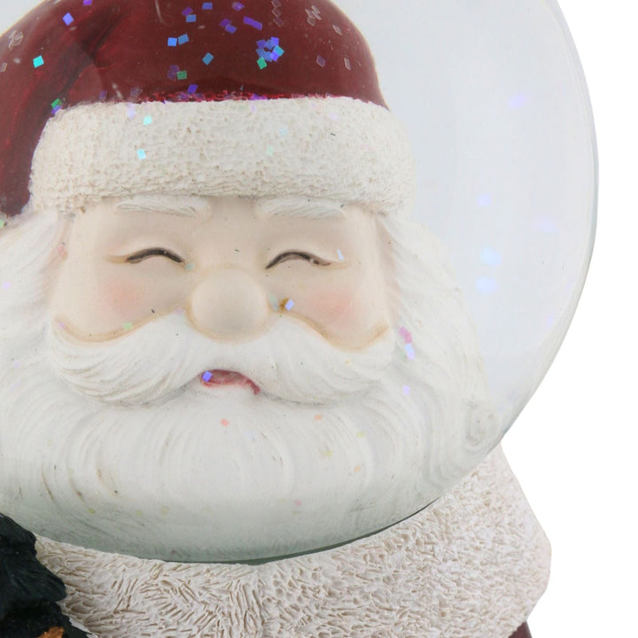 detail shot of Santa Claus figure inside a snow globe with a white background