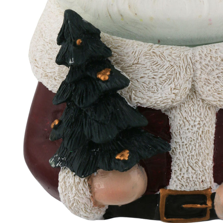 close up of green tree with gold details on santa claus snow globe
