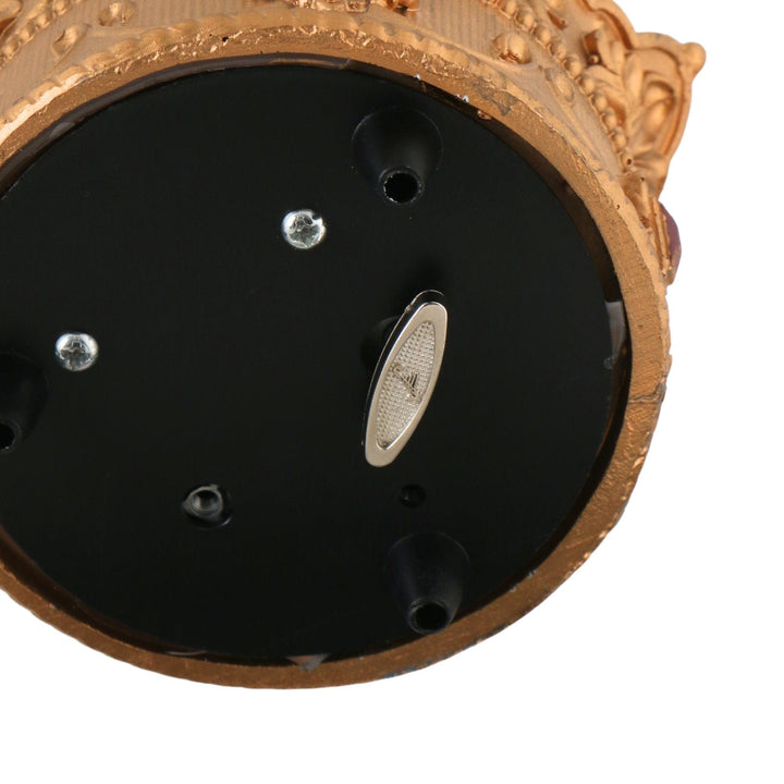 close up of snow globe base with turning mechanism to play music