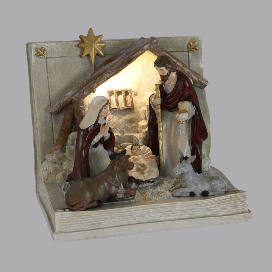 nativity book ornament in low light with warm white LED light shining