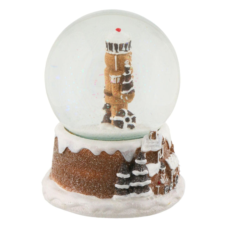 side view of now globe with a gingerbread house scene on a white background