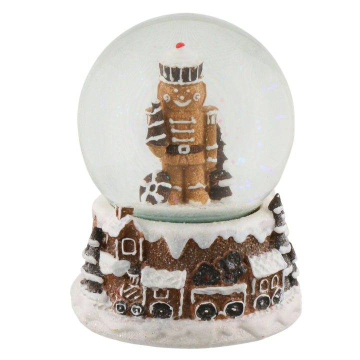 Snow globe with a nutcracker & gingerbread design on a white background