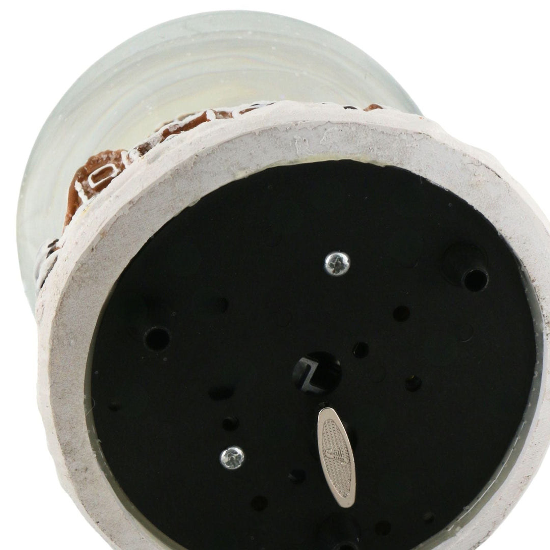cose up of snow globe base with wind up mechanism to play music