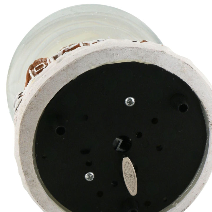 cose up of snow globe base with wind up mechanism to play music