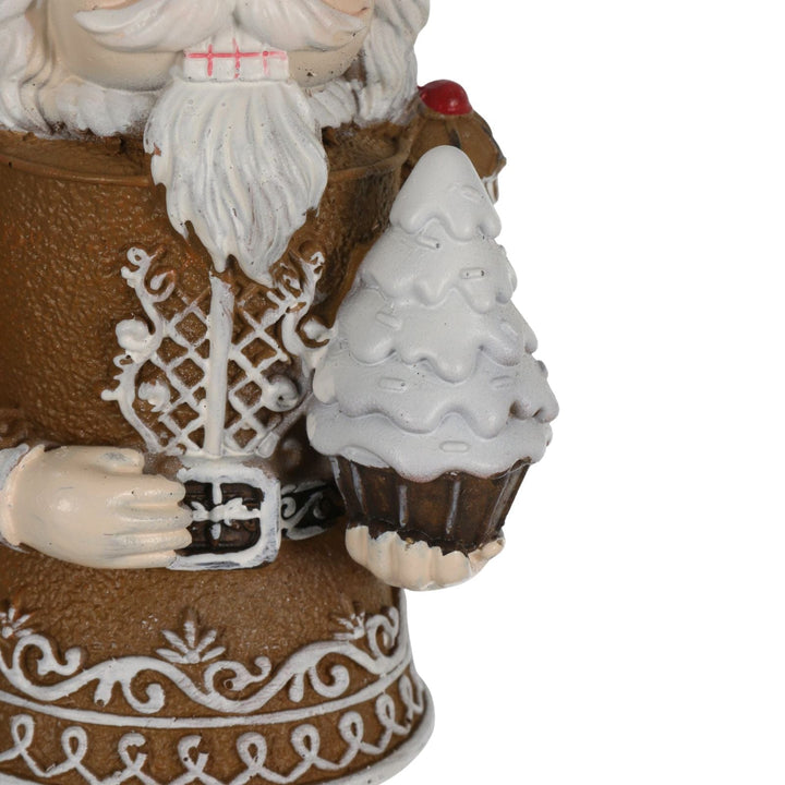 Decorative gingerbread man figurine holding a cupcake christmas tree with a white background