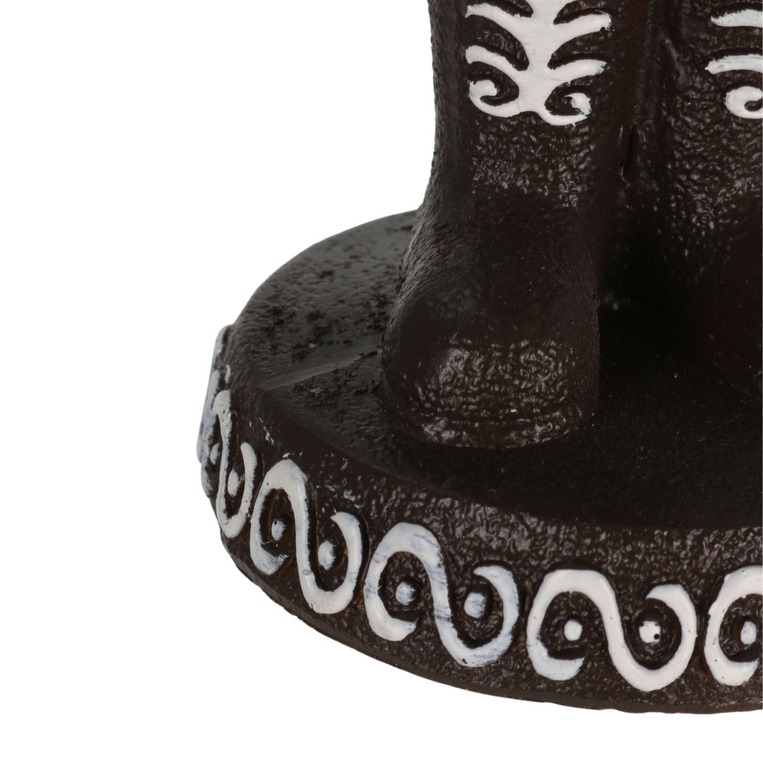 detail shot of gingerbread nutcracker figure boots on icing chocolate style platform with white swirl detail