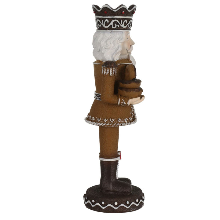 side view of nutcracker figurine holding a pile of doughnuts