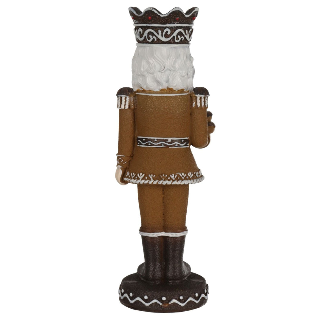 back view of gingerbread style nutcracker wearing crown with icing and cherry details