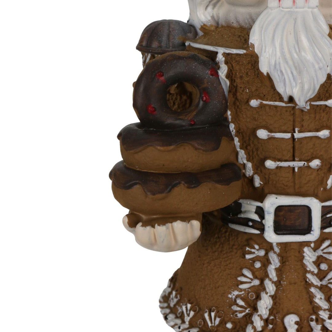 Gingerbread nutcracker man with a stack of donuts on a white background