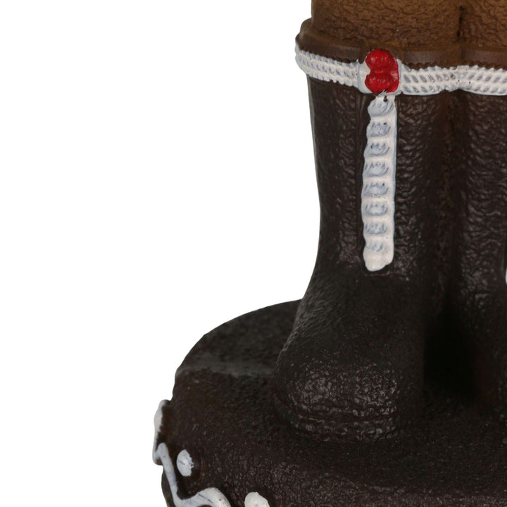 close up of nutcracker gingerbread man boots with icing and cheery details on cookie style platform